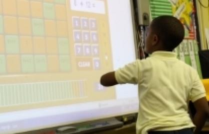 Boy in front of electronic whiteboard